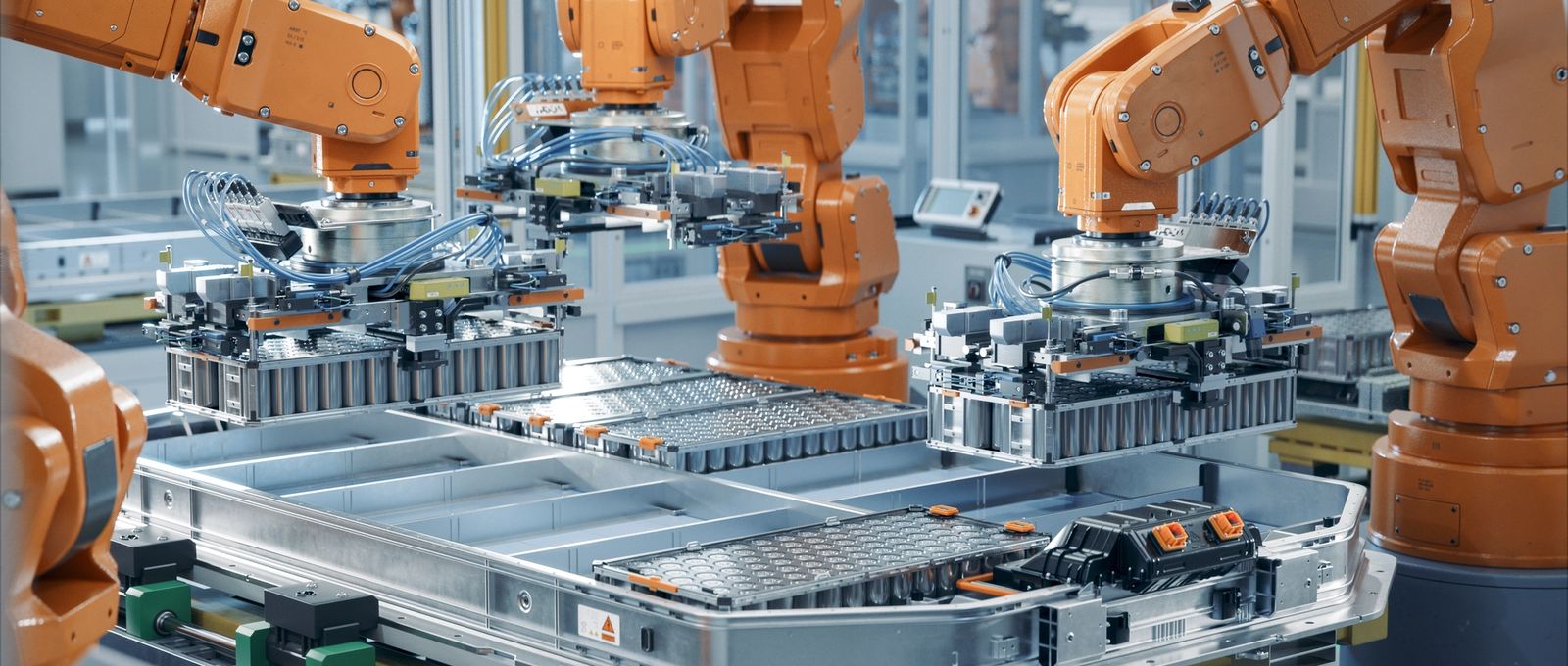 Những robot màu cam làm việc trên dây chuyền sản xuất pin